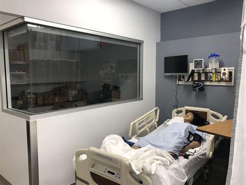A training dummy laying in a hospital bed