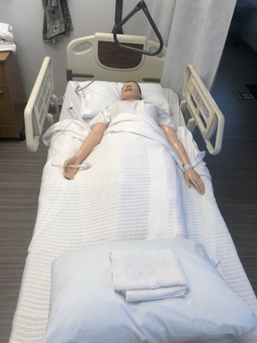 A dummy laying in a medical bed